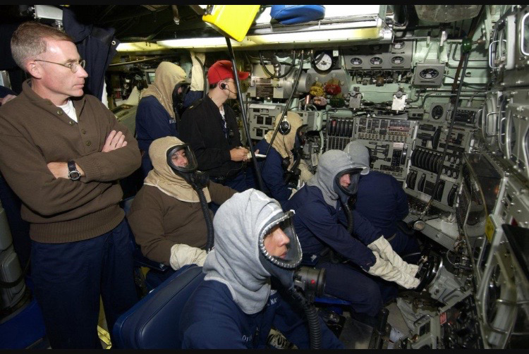 A scene from a 688 Class submarine control room/attack center during a drill. You can tell it's a drill because some people don't have to suck rubber. The red hat is a drill monitor. (Image source: submarine museum.oncell.com)