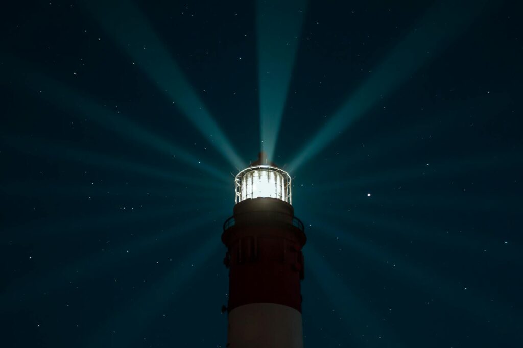 illuminated lighthouse under night sky