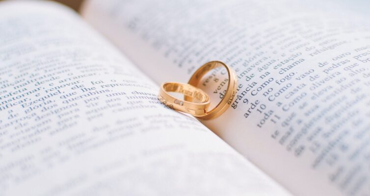 two gold colored wedding bands on book page