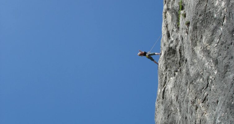 man standing on rock against clear blue sky