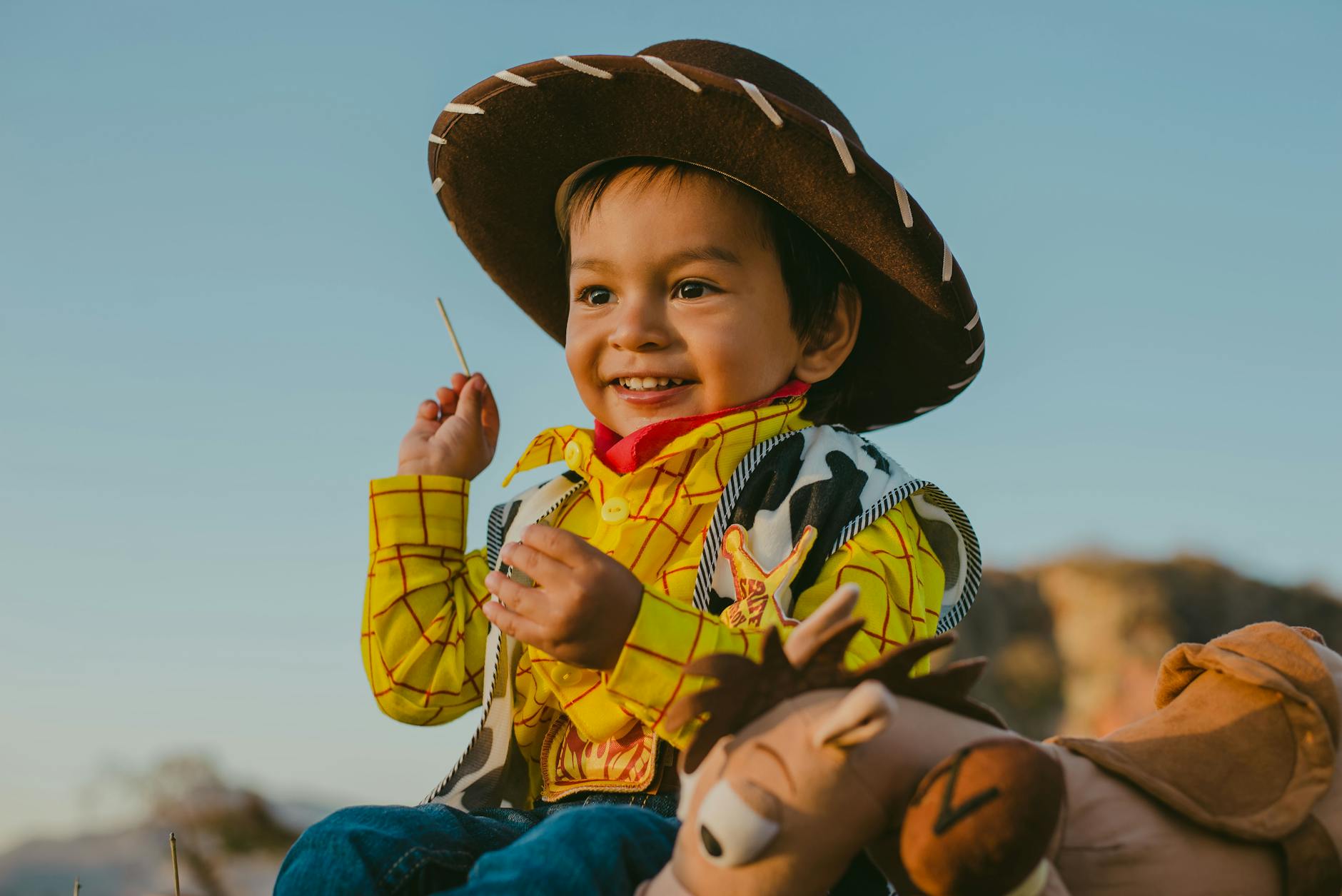 a young boy smiling in woody costume