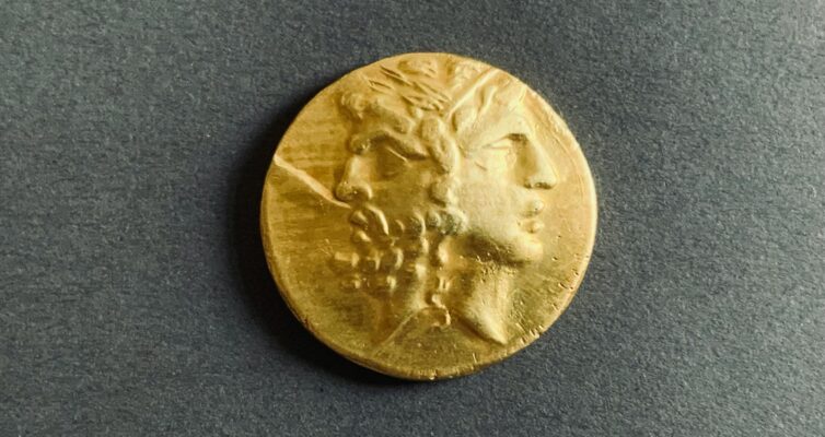 ancient golden coin on dark background