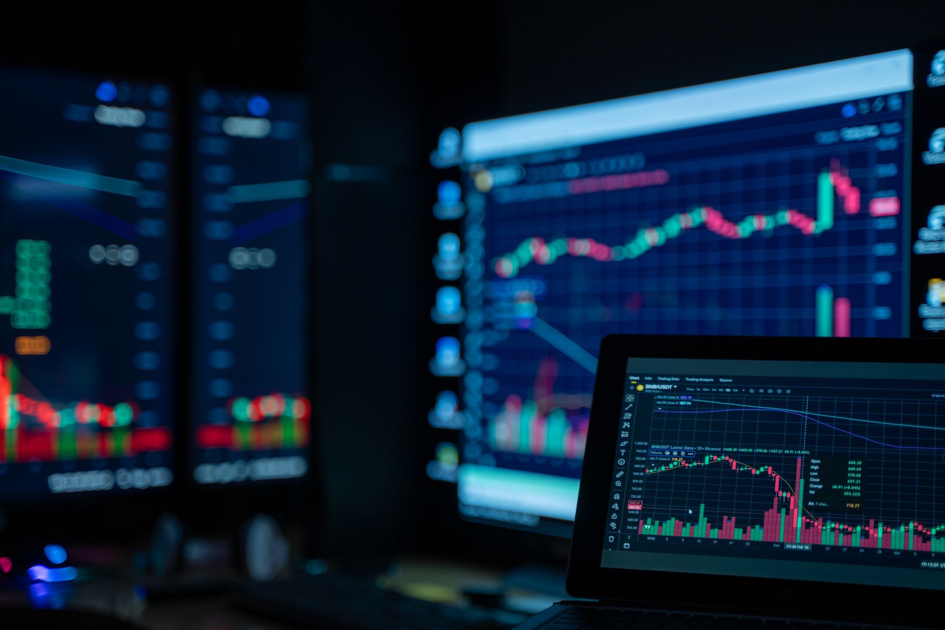 digital stock market charts on multiple screens