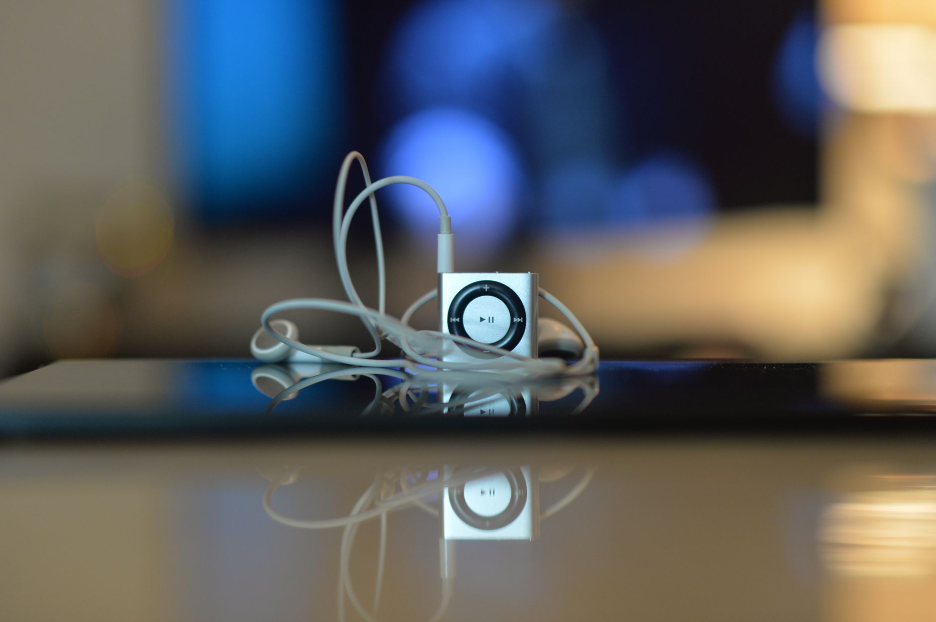 minimalist close up of small music player with earbuds